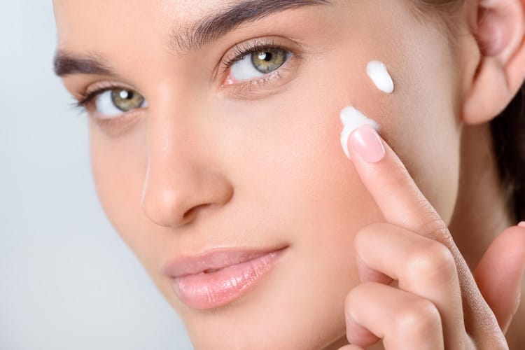 Woman applying skin care cream
