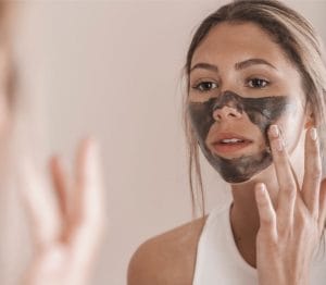 Woman applying Nordic Mud Peat Mask