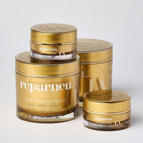 Four gold-colored jars from the réparneu Gold Large Set, designed for face, neck, and chest care, are arranged together against a plain light background.